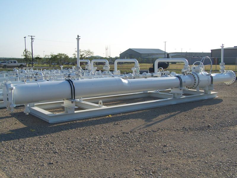 A white pig trap launcher and receiver assembly sitting in the yard