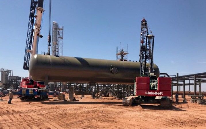 A pressure vessel being lifted by a crawler crane at a plant site